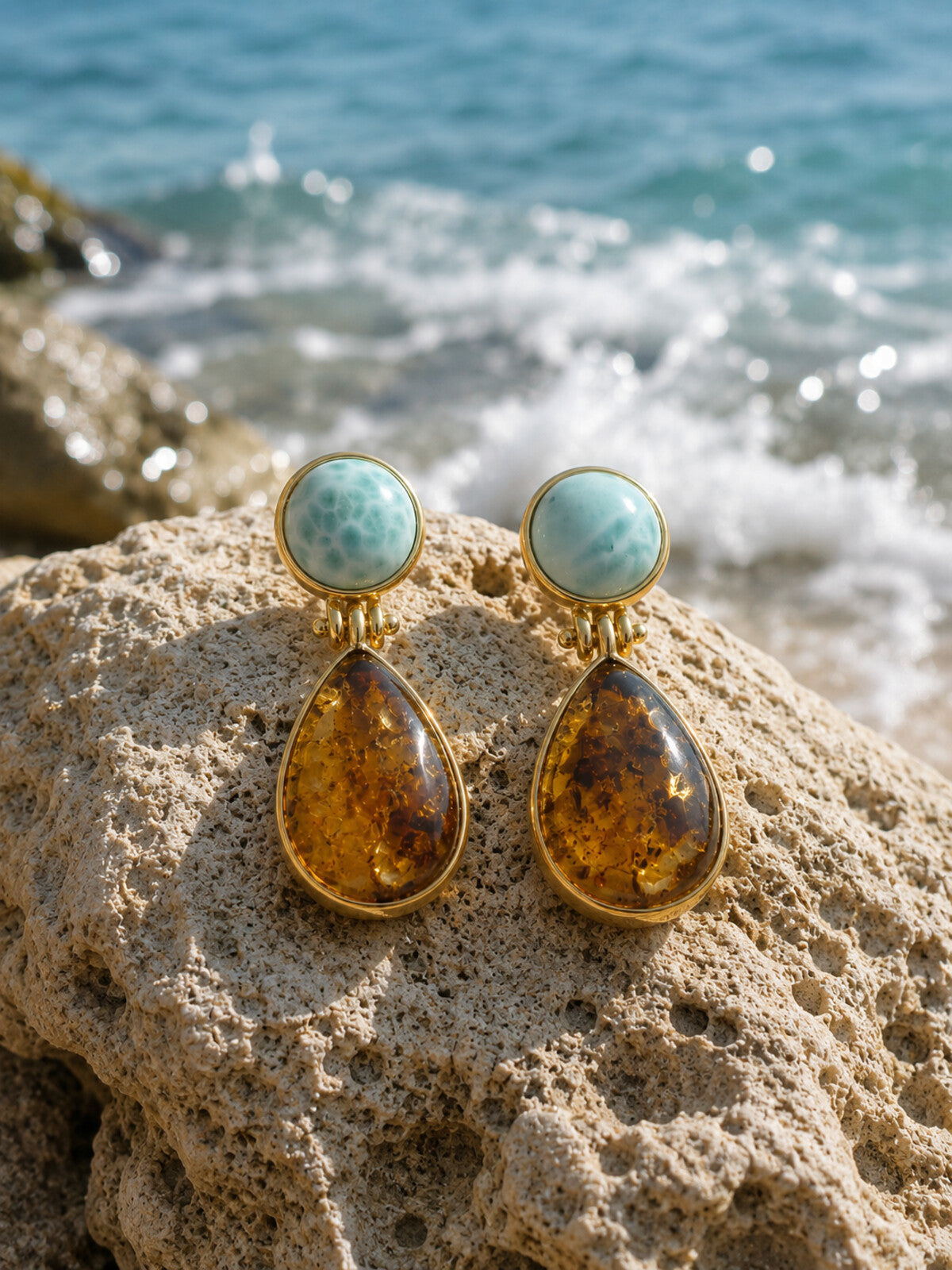 Amber teardrop earrings with larimar, photographed on the beach