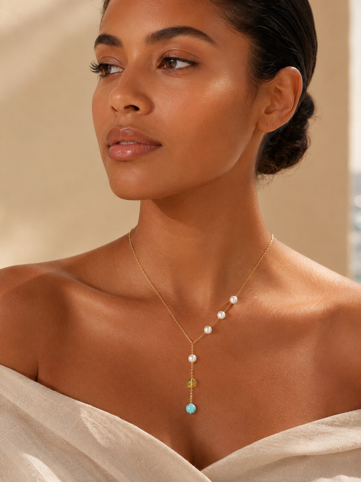 Larimar, amber and pearl pendant necklace, worn by a model