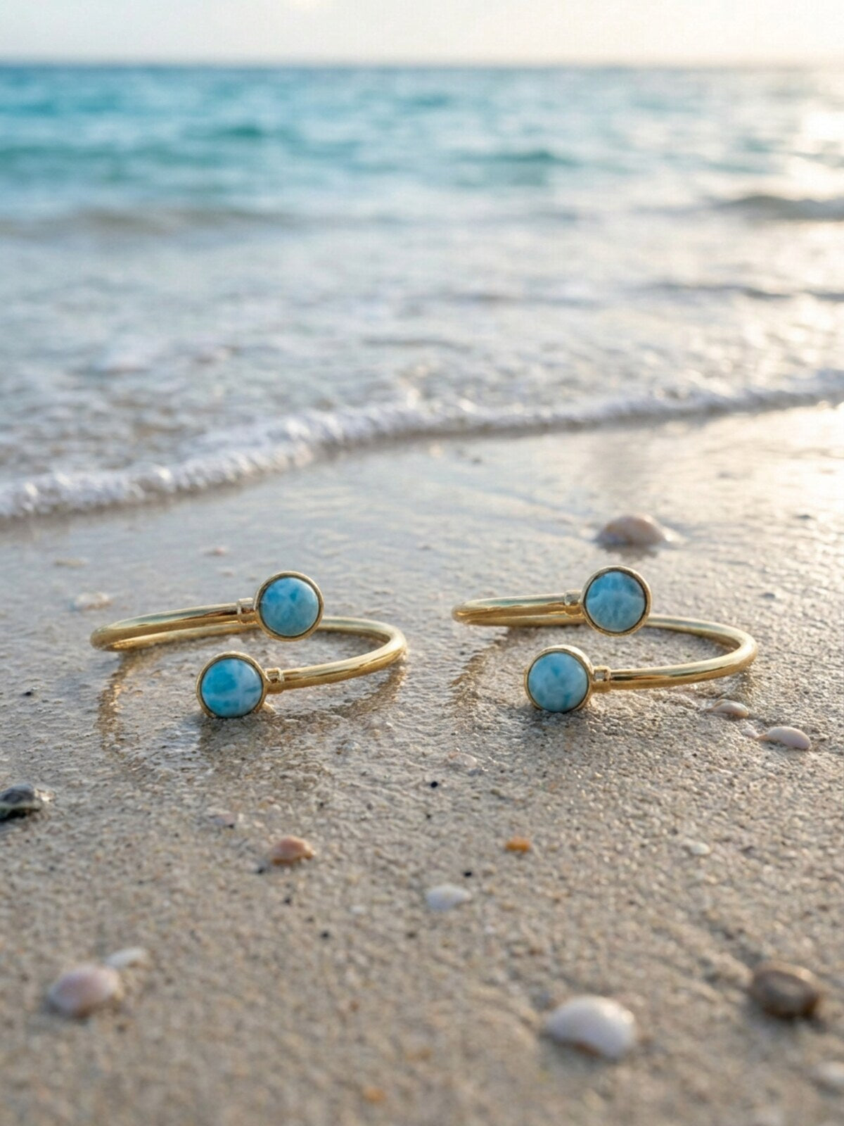 Two larimar bracelets, on the sand by the sea