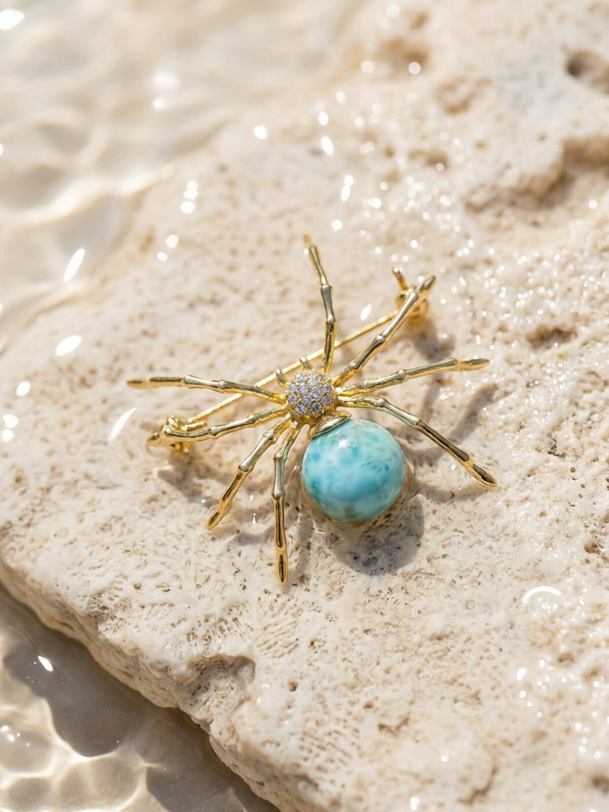Larimar spider brooch, photographed on the beach