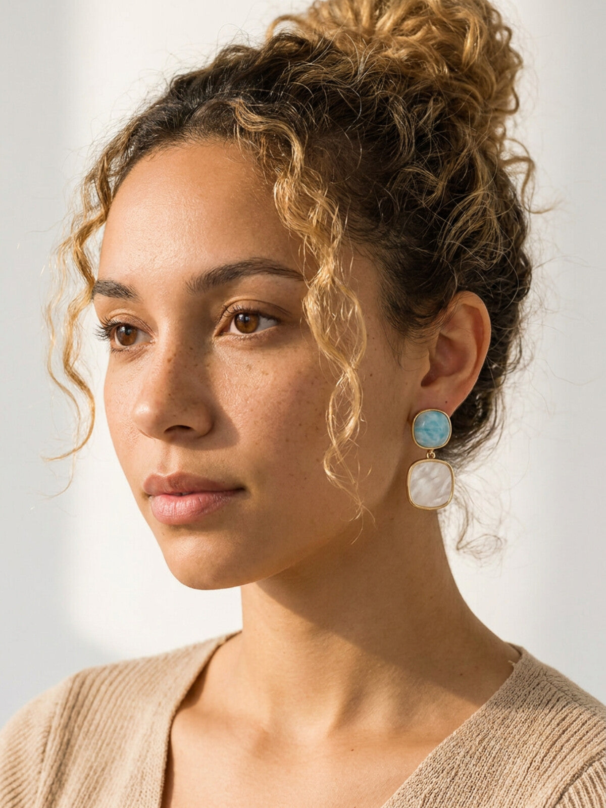 Larimar and mother-of-pearl earrings, worn by a model