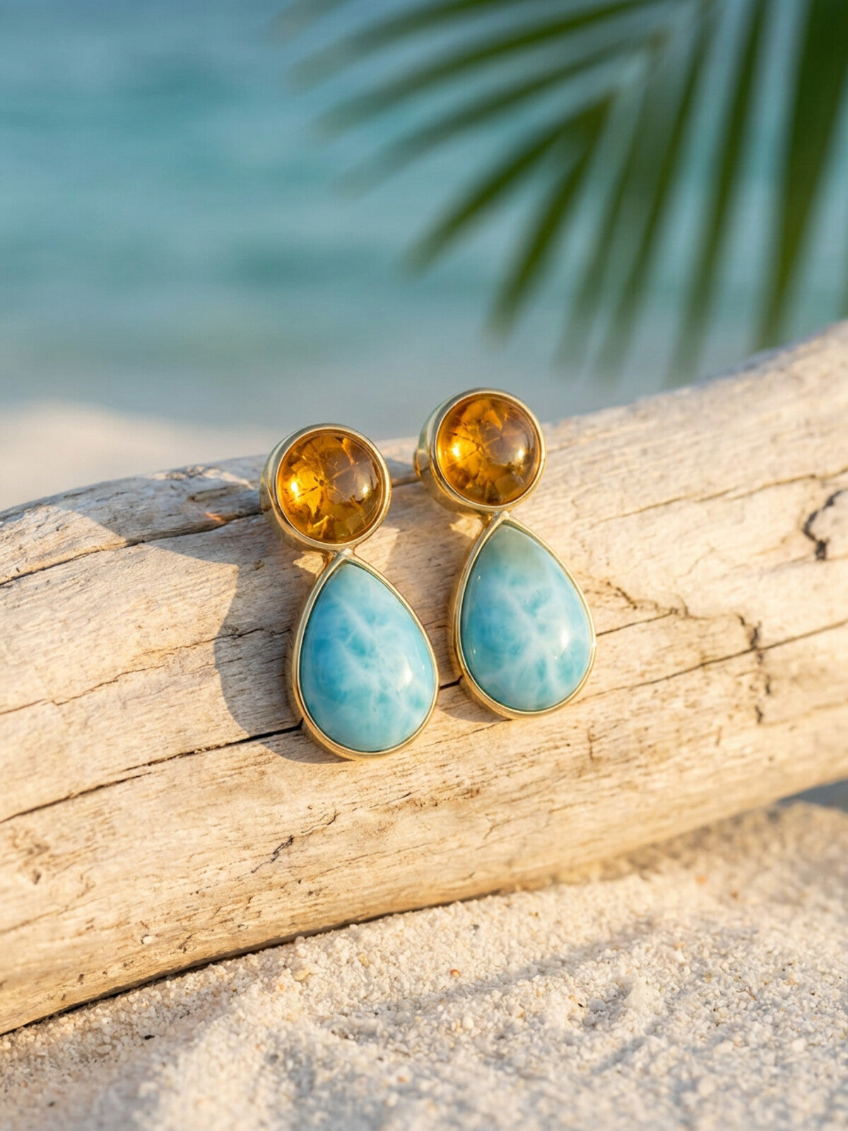 Larimar and amber drop earrings, photographed on the beach