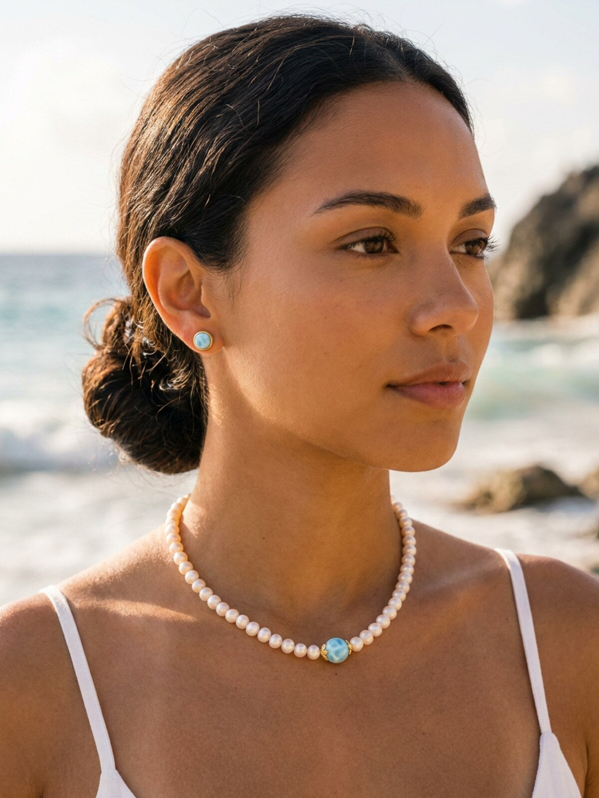 Pearl necklace with larimar bead, worn by a model